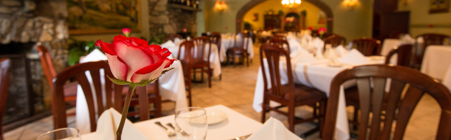 a rose sits in a bud vase of one of the restaurants elegantly arranged dining rooms