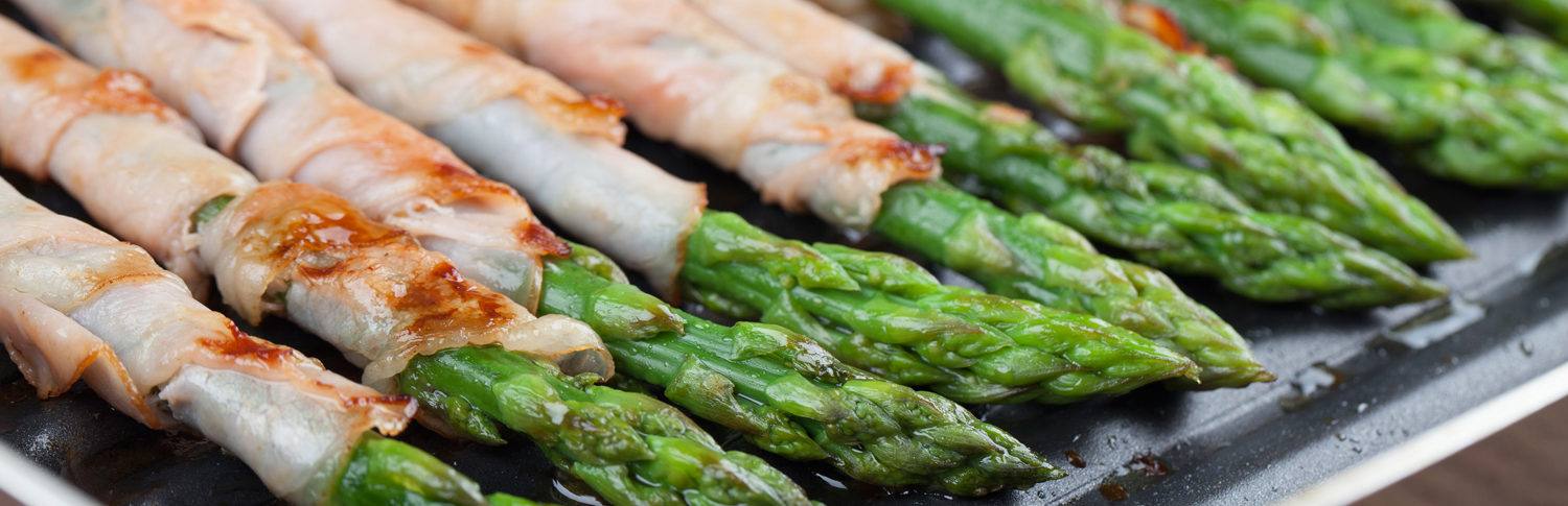 asparagus appetizer, wrapped in prosciutto and topped with a glaze