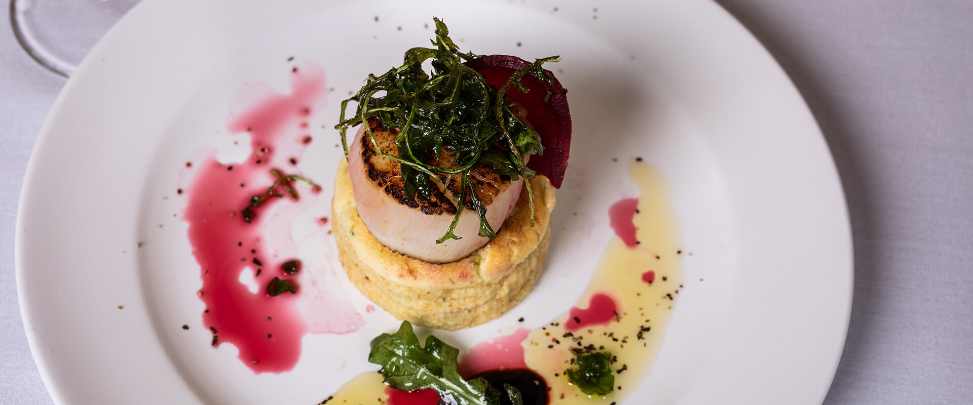 scallop with oil and red wine vinegar on a white plate